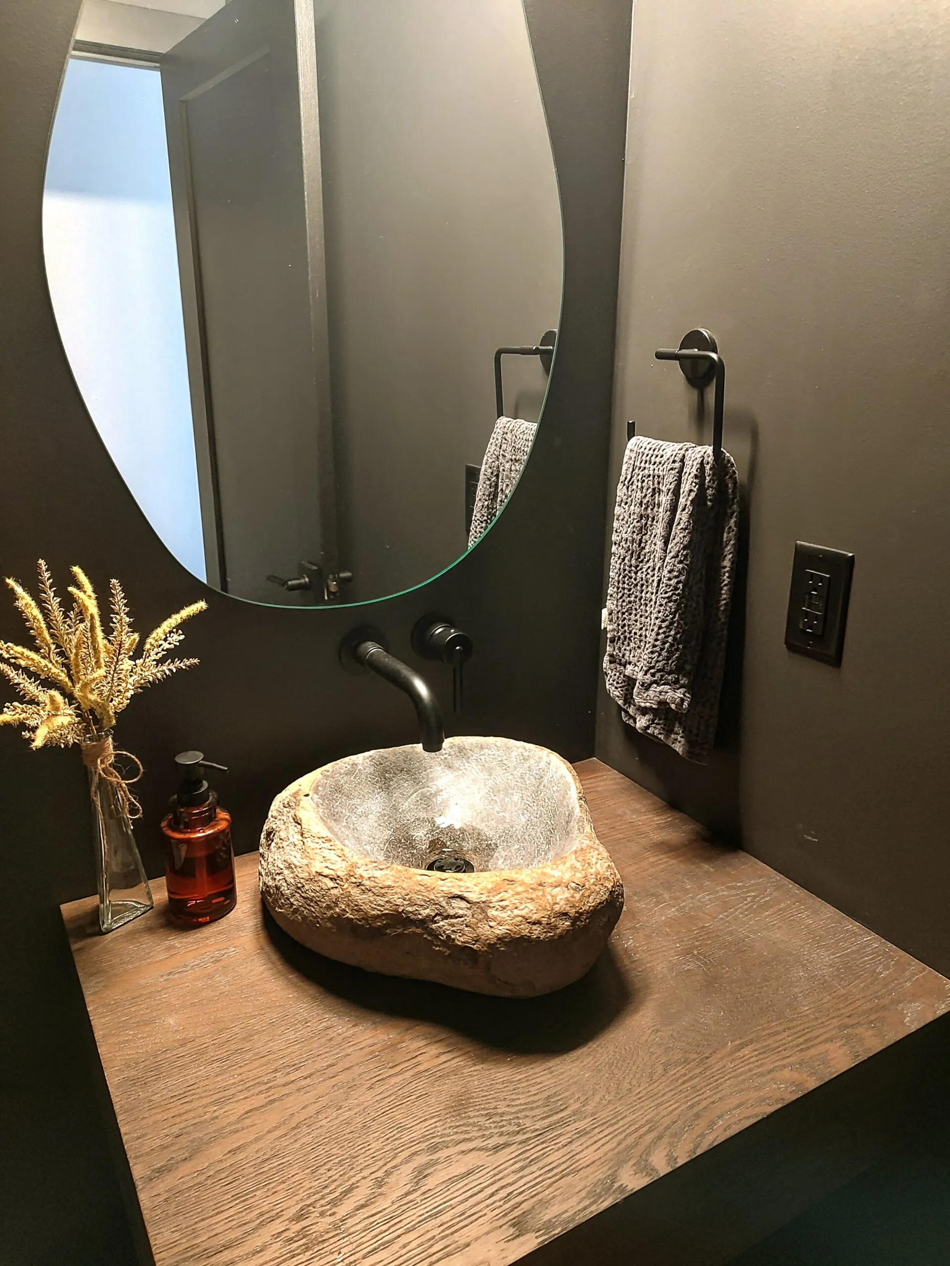 Natural stone vessel sink on a live edge wood counter in a powder room